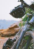 Mountainbike angelegt an einem Stein mit Helm am Lenker