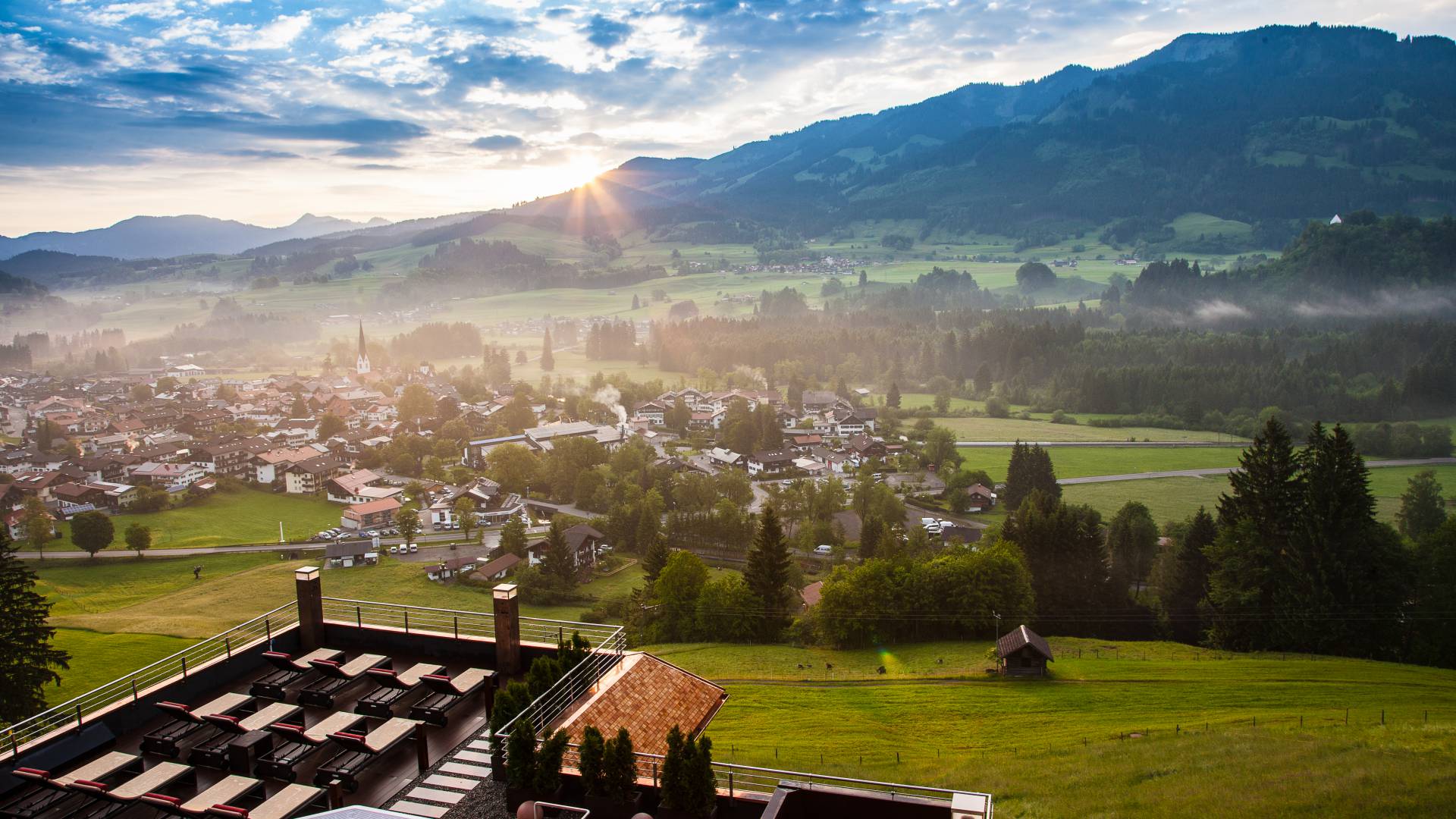 Panoramabild auf Fischen im Allgäu mit untergehender Sonne an der Bergkette
