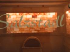 Glastür mit Schriftzug Salzstadl im Hintergund eine Wand voller Salzsteine