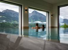 Pärchen genießt die Aussicht vom Infinity Pool aus zu den Bergen