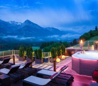 Paar erholt sich im Whirlpool im Hintergrund Berglandschaft in der Dämmerung