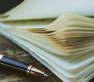 Nahaufnahme eines Notizheftes mit einem Kugelschreiber nebenan