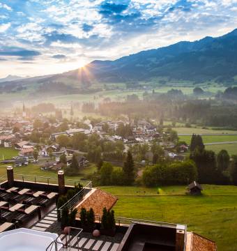 Panoramabild auf Fischen im Allgäu mit untergehender Sonne an der Bergkette