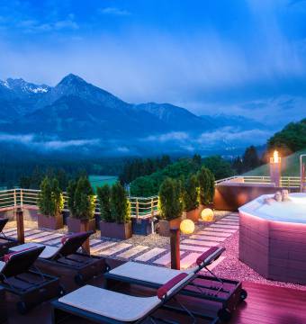 Paar erholt sich im Whirlpool im Hintergrund Berglandschaft in der Dämmerung