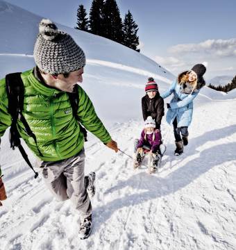 Familie beim Rodeln im Allgäu