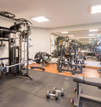 Fitnessraum in Hotel Tanneck mit Kraftmaschine und Spiegel