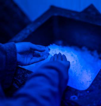 Person bedient sich am Eisbrunnen nach einem Saunagang