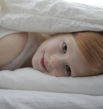 Kind liegt unter der Decke