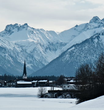 Winter im Allgäu mit schneebedeckten Bergen und Kirchen