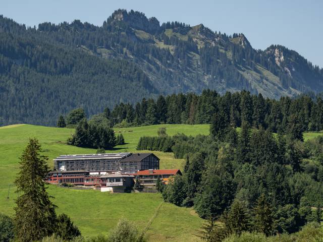 Hotel Tanneck in Fischen im Sommer zwischen grünen Wiesen und Bäumen
