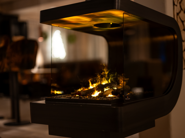 Moderner Kamin mit Feuer und geschwungenen Gestell