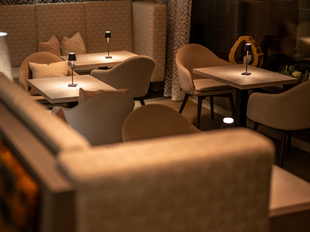 Gemütliche Sessel im Restaurant mit kleinen Leuchten auf den Tischen