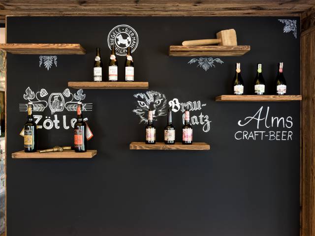 Wand mit Regalen und verschiedenen Biersorten aufbreitet