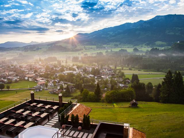 Panoramabild auf Fischen im Allgäu mit untergehender Sonne an der Bergkette