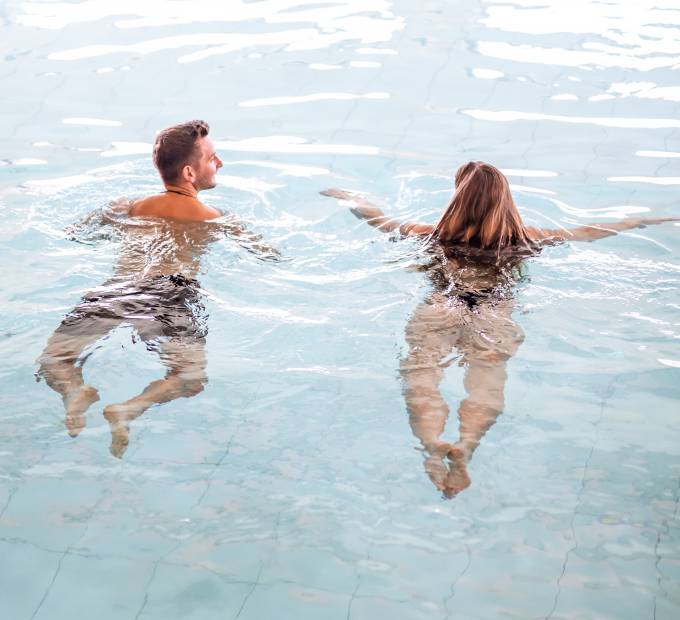 Personen schwimmen im Innenpool